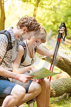 Hikers backpackers couple reading map on trip.