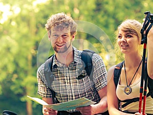 Hikers backpackers couple reading map on trip.