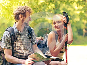 Hikers backpackers couple reading map on trip.