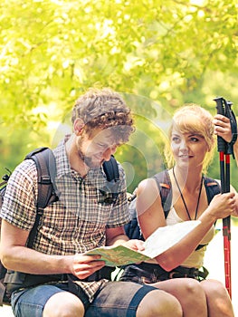 Hikers backpackers couple reading map on trip.