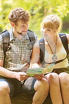 Hikers backpackers couple reading map on trip.