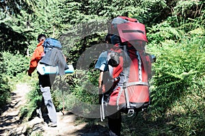 Hikers with backpacks in mountain and enjoying the view of valley