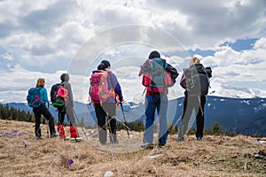 Hikers with backpacks and nordic walking sticks enjoying of mountain landscape