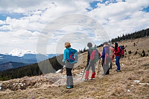 Hikers with backpacks and nordic walking sticks enjoying of mountain landscape