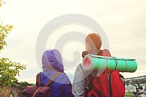 Hikers with backpacks on top of mountain enjoying life and beautiful view on valley