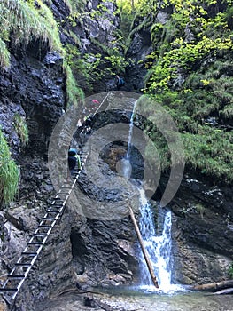 Hikers climb stairs up to gorge near waterfall