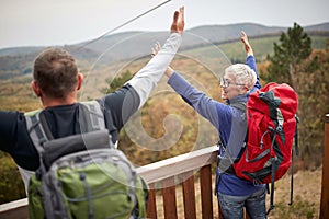 Hikers couple with raise arms looking landscape