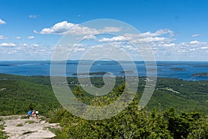 Hikers in the distance overlooking Frenchman`s Bay on the way to Cadillac Mountain in Acadia National Park, Maine, USA