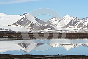 Hikers dwarfed by Arctic Glacier