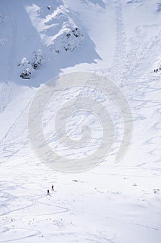Hikers going through alpine snowy terrain during winter, vertical shot, Slovakia, Europe