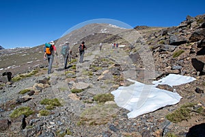 Hikers going up to Mulhacen through a mountainous area with a bit of snow photo