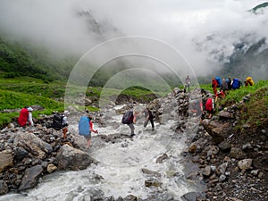 Hikers group cross the mountain river