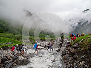 Hikers group cross the mountain river