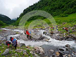 Hikers group cross the mountain river