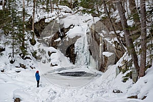 Hikers near frozen Kinsman Falls in Franconia Notch State Park during winter . New Hampshire mountains. USA photo