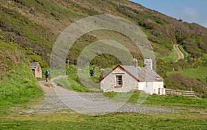 Hikers by cottage near Hartland Quay in Devon photo
