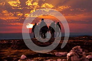 Hikers reach mountain top at sunset