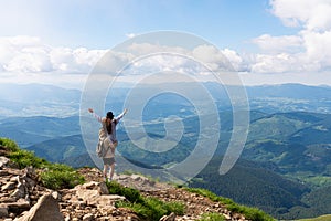 Hikers relaxing on top of a mountain and enjoying the view of valley