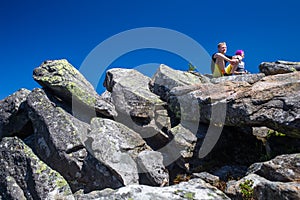 Hikers rest on the stone while hiking