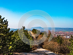 Hikers resting on a hilltop with the panoramic view of Pilis mountains in the background