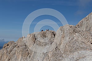 Hikers take a break enjoying sun on a big rock formation, Trentino-Alto Adige, Italy