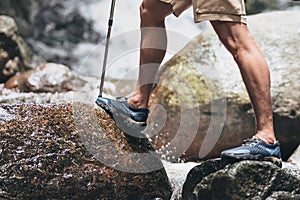 Hikers use trekking pole with backpacks walking through the rock and water on stream in the forest. hiking and adventure concept
