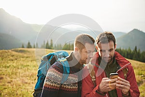 Hikers using a cellphone while out trekking in the wilderness