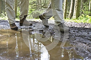 Hikers Walking Through Mud Puddle