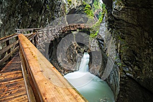 Hiking along a woodend boardwalk in a canyon near Kaprun, Austria