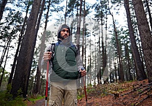 Hiking, backpack and man in forest for shelter, survival and dangerous conditions. Nature, winter and male person with