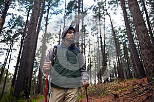 Hiking, backpack and man in forest for travel, survival and dangerous conditions. Nature, winter and male person with