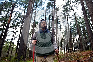 Hiking, backpack and man walking in forest for survival, shelter and rough terrain. Nature, winter and male person with