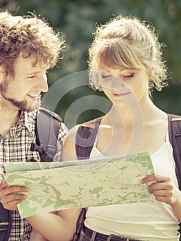 Hiking backpacking couple reading map on trip.