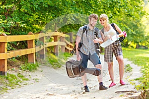 Hiking backpacking couple reading map on trip.