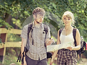 Hiking backpacking couple reading map on trip.