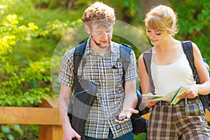 Hiking backpacking couple reading map on trip.