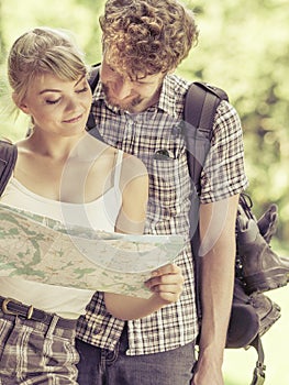 Hiking backpacking couple reading map on trip.