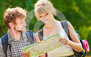 Hiking backpacking couple reading map on trip.