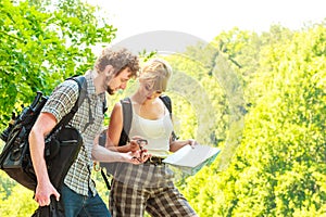 Hiking backpacking couple reading map on trip