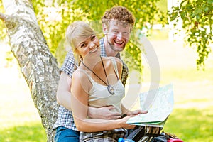 Hiking backpacking couple reading map on trip