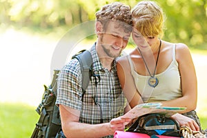 Hiking backpacking couple reading map on trip.