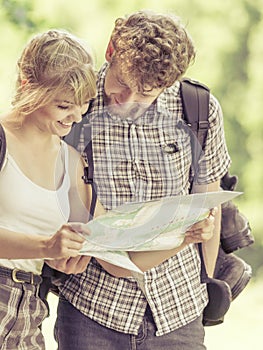 Hiking backpacking couple reading map on trip.