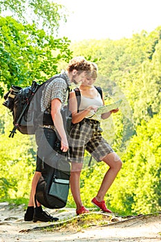 Hiking backpacking couple reading map on trip.