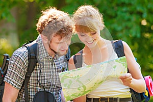 Hiking backpacking couple reading map on trip.