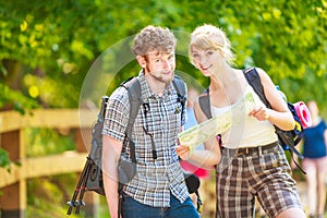 Hiking backpacking couple reading map on trip.