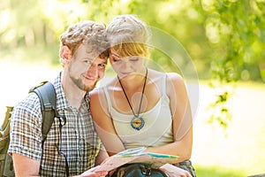 Hiking backpacking couple reading map on trip.