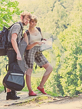 Hiking backpacking couple reading map on trip.