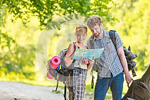 Hiking backpacking couple reading map on trip.