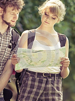 Hiking backpacking couple reading map on trip.