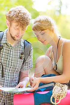 Hiking backpacking couple reading map on trip.